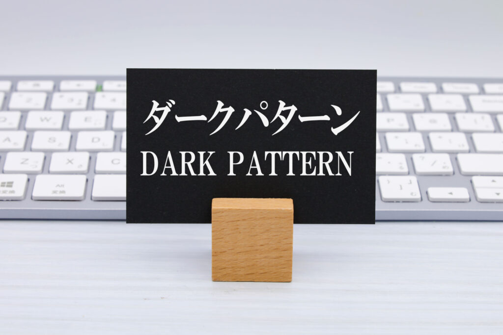 キーボードの前にダークパターンと書かれたカードが立っている
