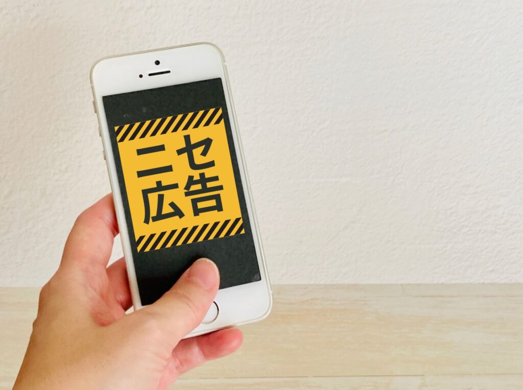 スマホ画面に「ニセ広告」と表示されている